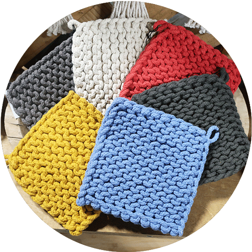 A collection of crocheted potholders in gray, cream, red, blue and yellow.